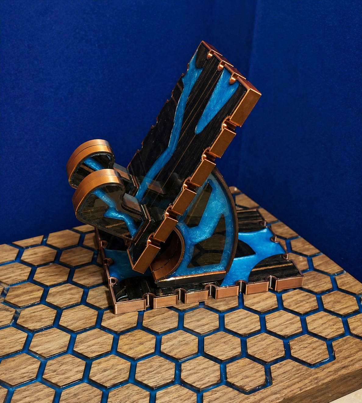 Metallic bookend with blue and bronze finish on a hexagonal patterned surface against a blue background